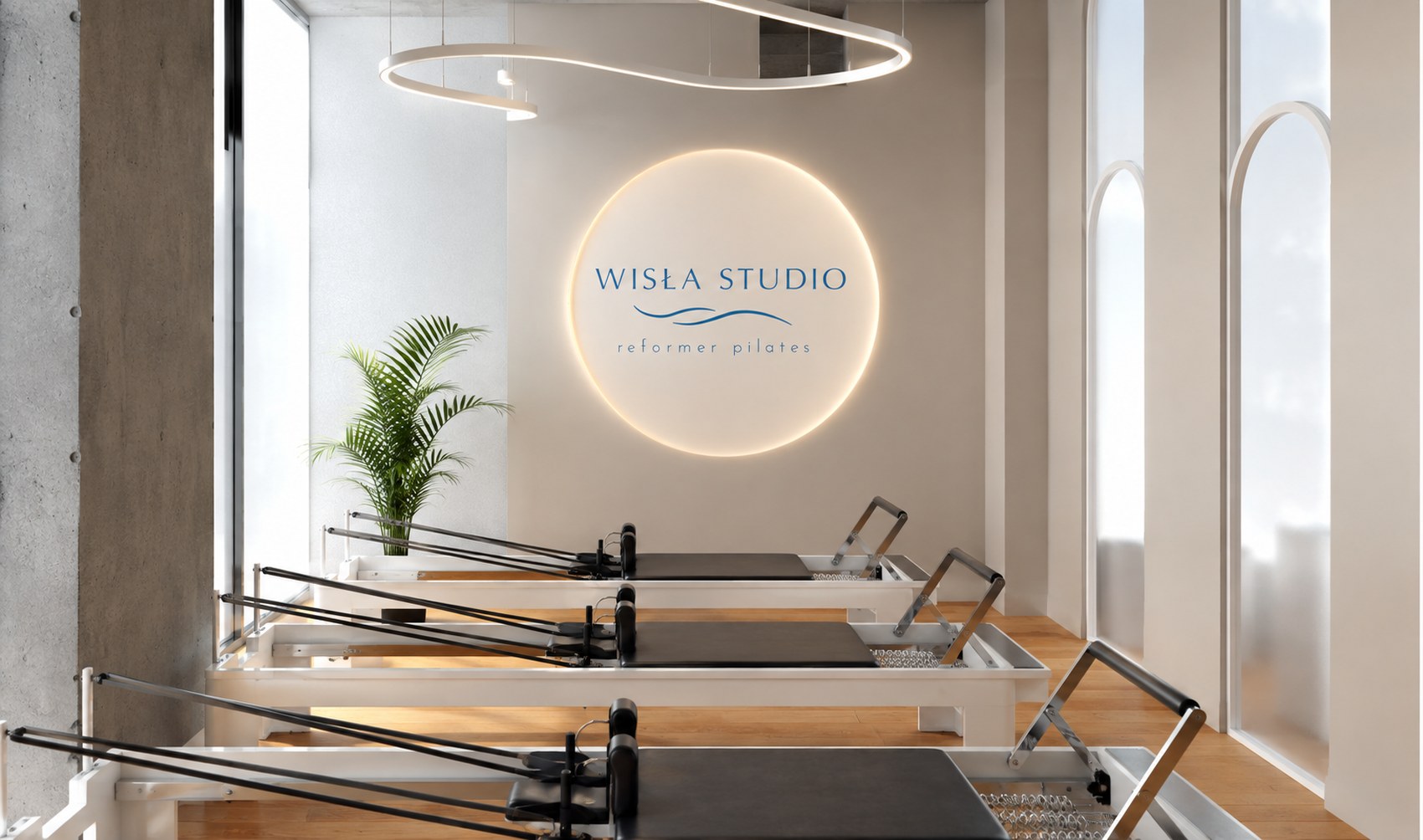 Sala ćwiczeń Wisła Studio — reformery i podświetlany znak fali